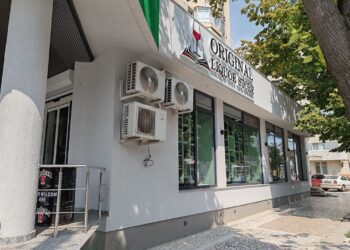 Ciocniți un pahar de șampanie în fața magazinului Original Liquor Store cu ocazie sărbătorii de Sf. Maria